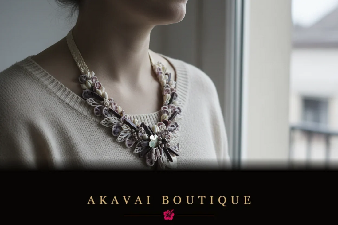 Collier Akavai en coquillages porté sur un pull clair, près d’une fenêtre, lumière naturelle douce, décor urbain neutre et flouté