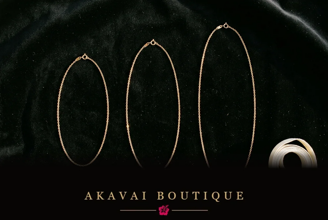 Trois chaînes dorées de longueurs différentes sur velours noir, accompagnées d’un ruban de mesure.