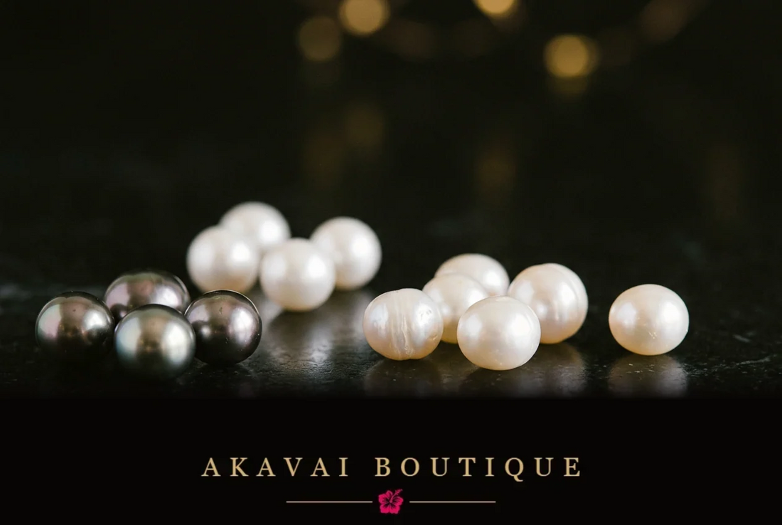 Perles aux nuances anthracite et ivoire sur une surface sombre, lumière chaude et reflets dorés, illustration du Journal d’Akavai sur les différents types de perles